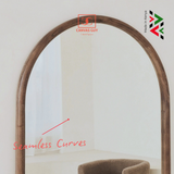 Wooden arch mirror with a chair underneath on a white background, featuring Canvas Guy branding.