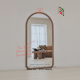 Arched mirror reflecting a living room with a sofa and table, branded 'Canvas Guy'.